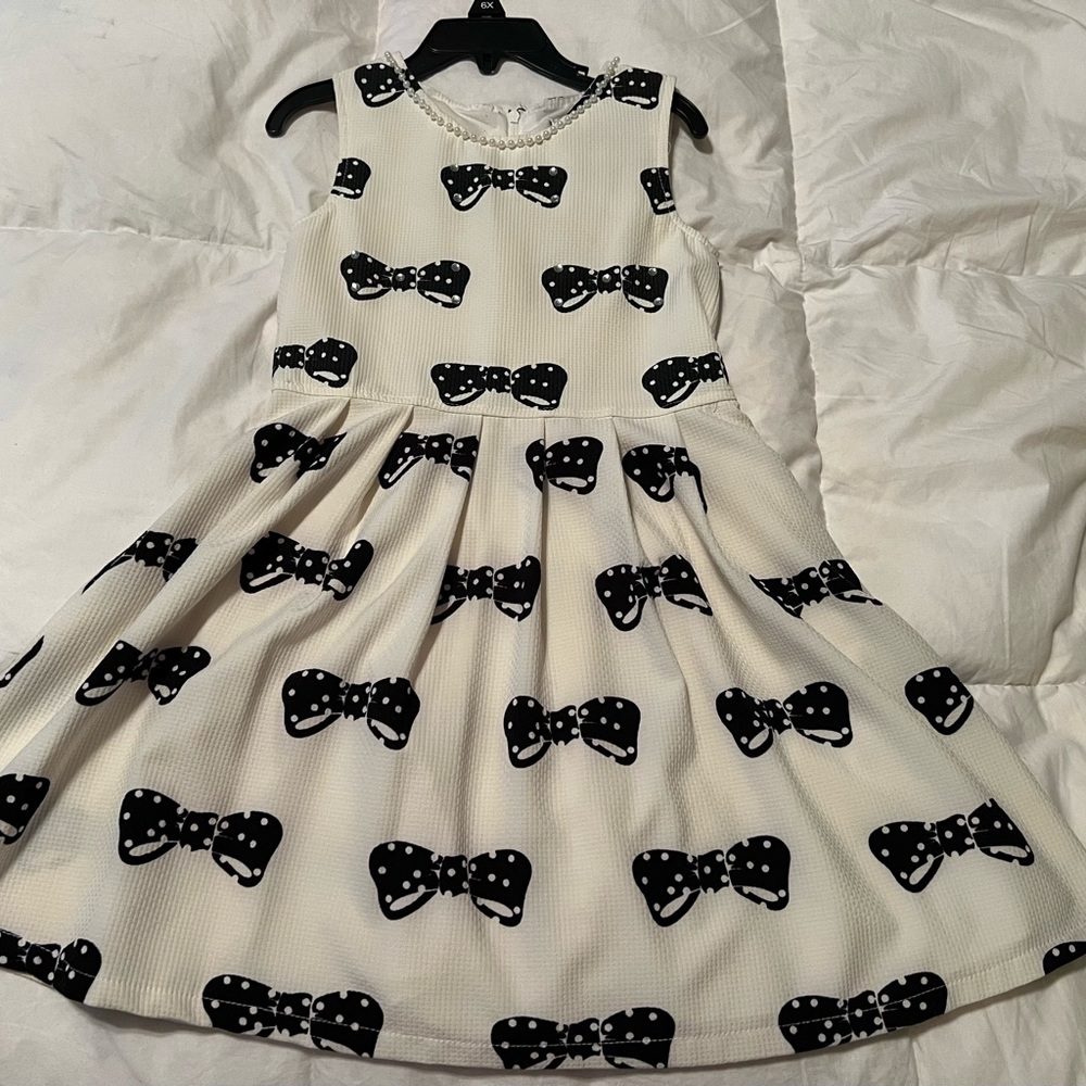 Cream dress with black bows accented with rhinestones and pearls